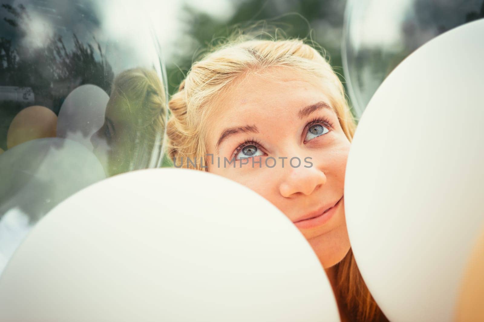 portrait of young girl with balloons on nature background.