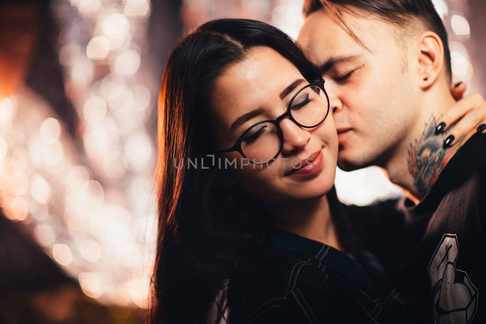 Couple in fashionable clothes on a shiny background.