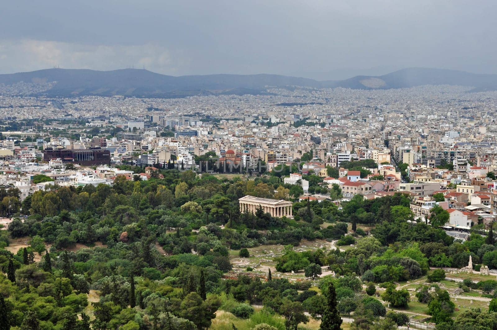 ATHENS, GREECE - MAY 6, 2014: View of the ancient agora with the temple of Hephaestus standing in contrast to the modern buildings of the city of Athens, Greece.
