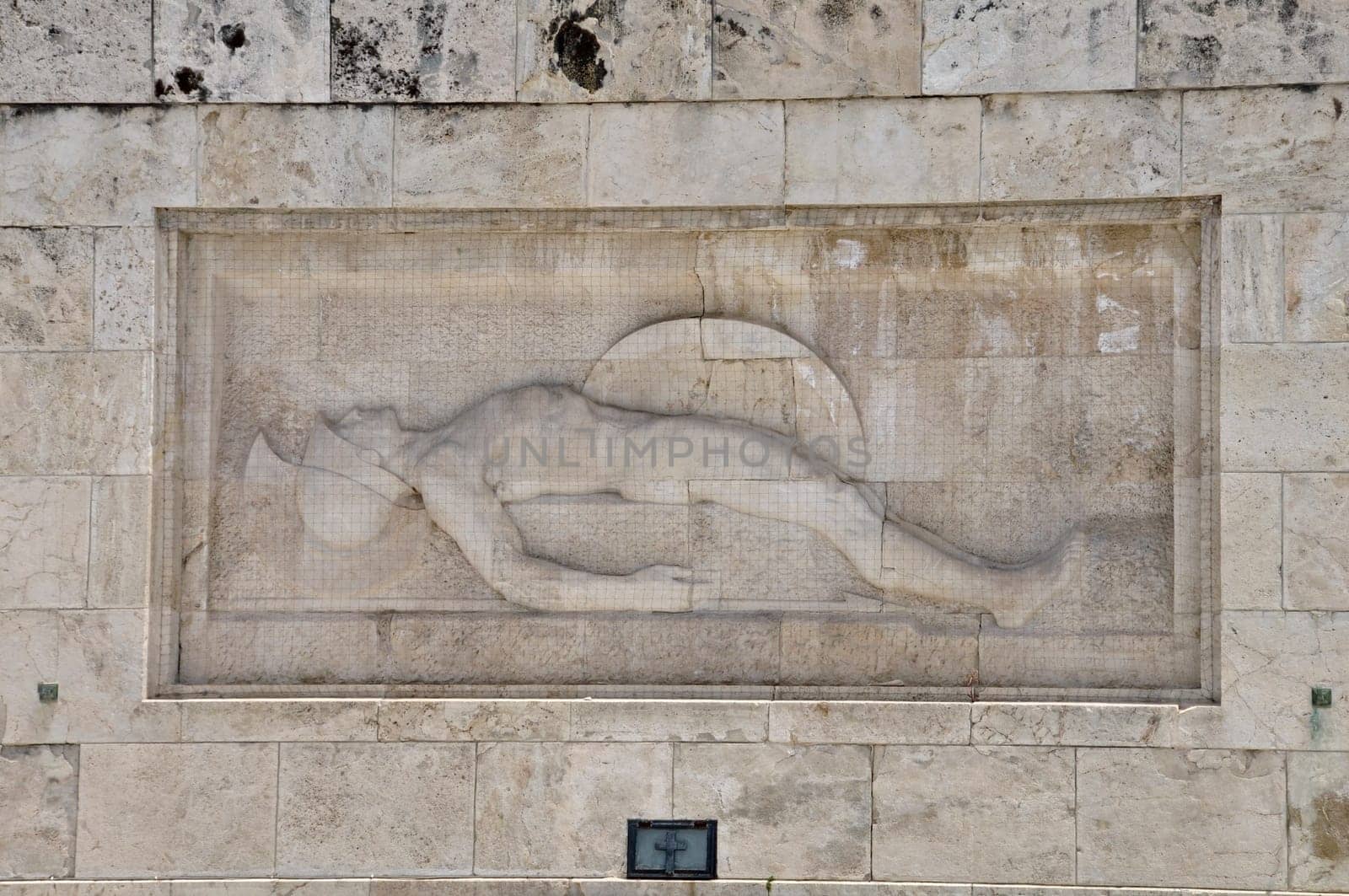 Tomb of the unknown soldier marble sculpture of dying ancient greek hoplite warrior holding his shield and spear, Athens Greece.