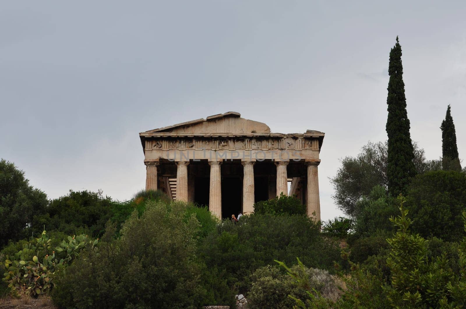 ATHENS, GREECE - SEPTEMBER 2, 2014: People visiting temple of hephaestus and lush vegetation at the ancient agora.