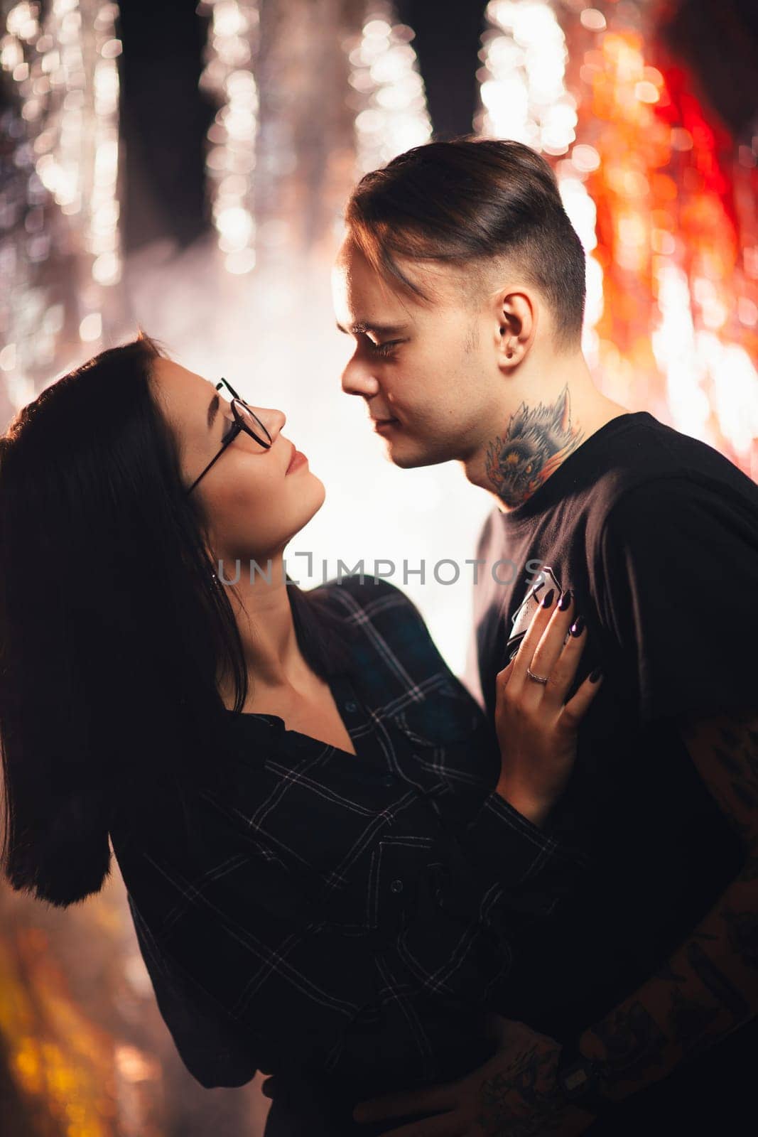 Couple in fashionable clothes on a shiny background.