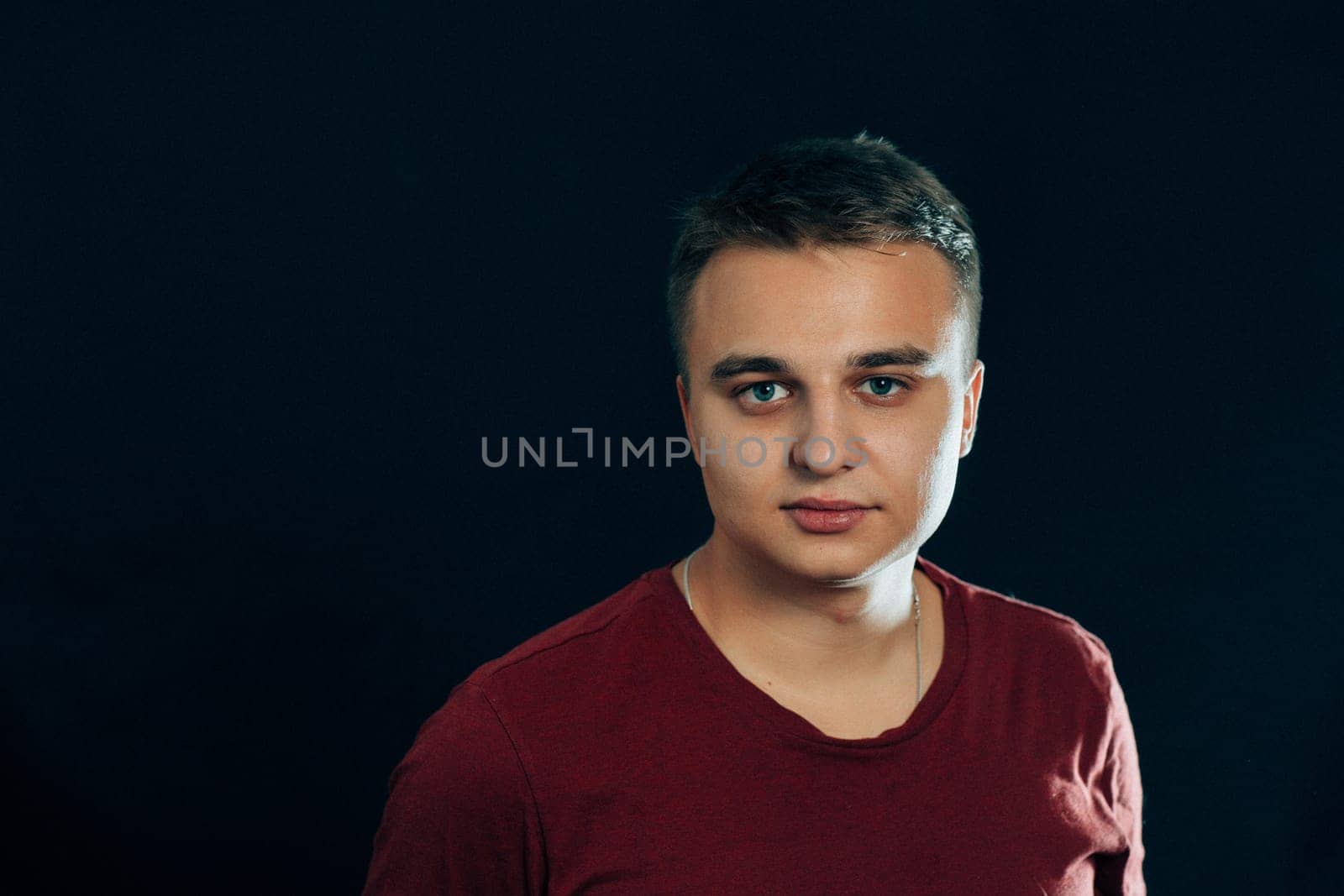 portrait of a young man on a dark background.