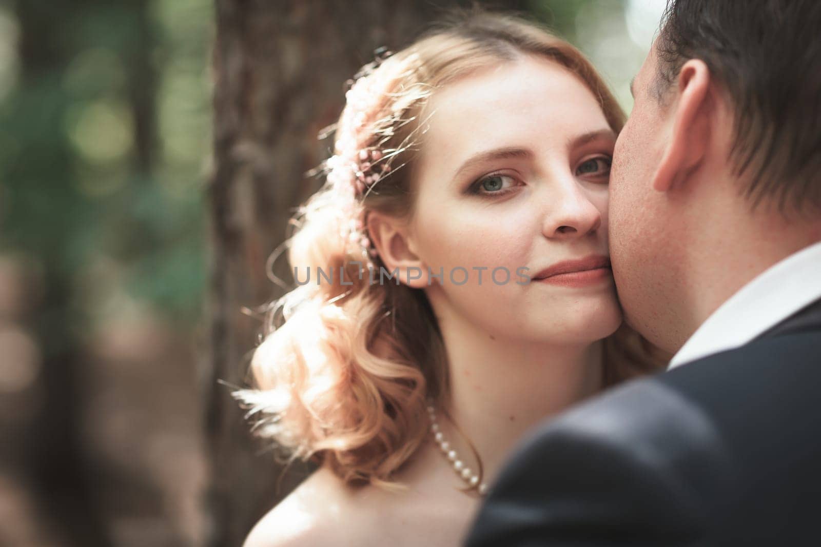 bride and groom on the background of trees and forest sun.