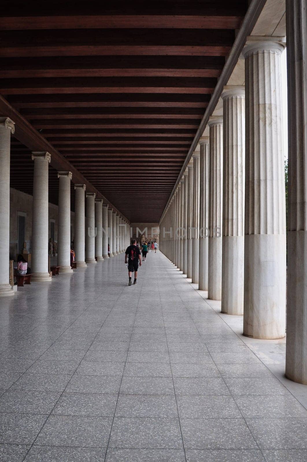 ATHENS, GREECE - SEPTEMBER 2, 2014: People visiting stoa of attalos covered walkway with ionic and doric columns in the ancient agora.