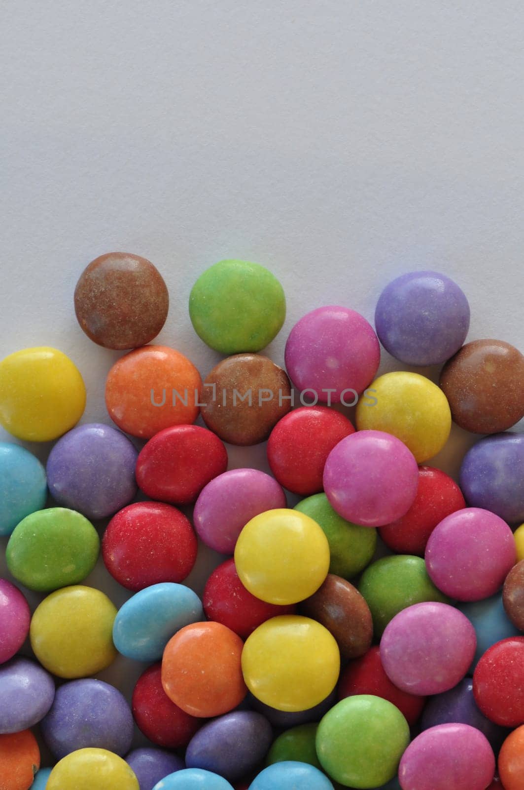 Colorful chocolate candy pieces on white background.