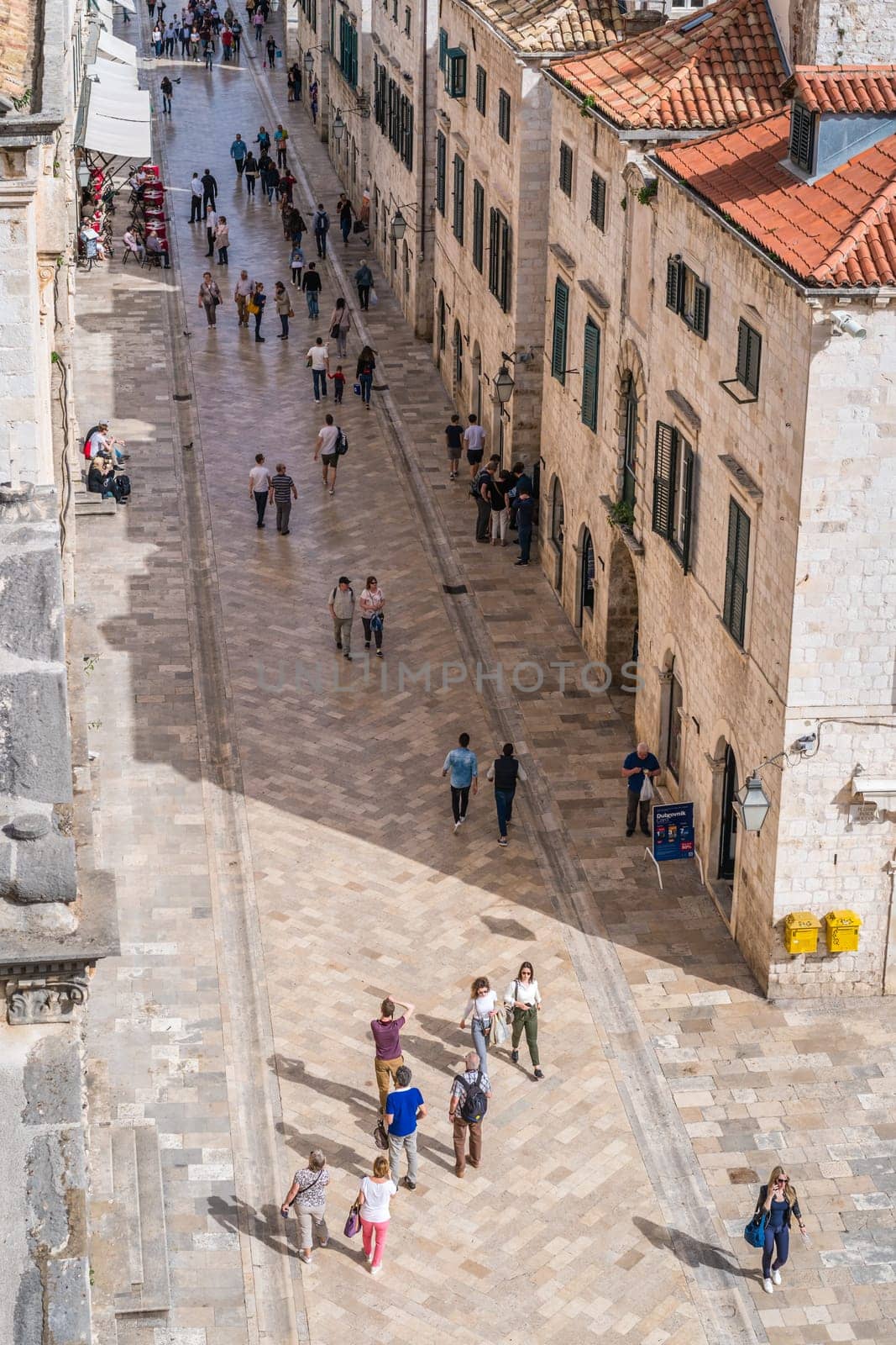 Dubrovnik, Croatia - April 2018 : Tourists walking on the main street between the old houses in Dubrovnik, viewed from the Old Town fortified walls