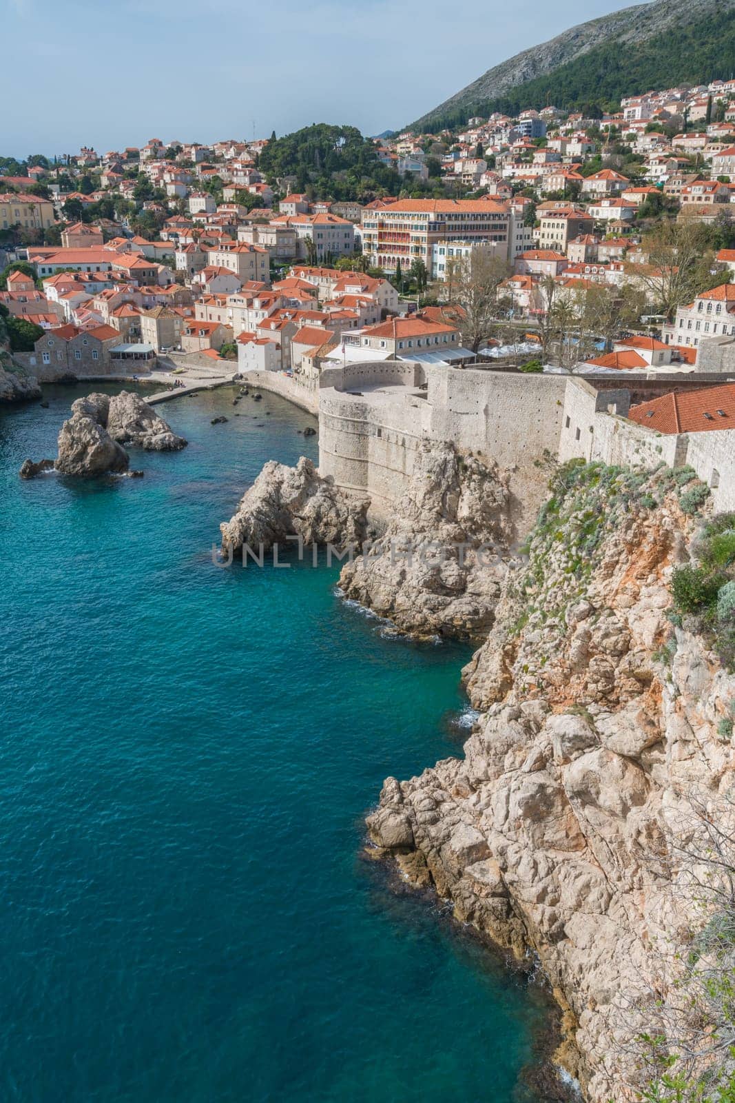 Dubrovnik, Croatia - April 2018 : Rocky coast alongside Dubrovnik Old Town massive defence walls of fortress Bokar