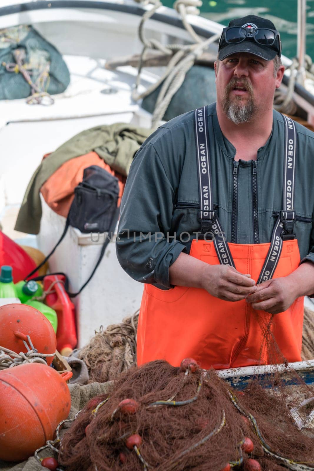 Dubrovnik, Croatia - April 2018 : Fisherman disentangling fish caught in the net