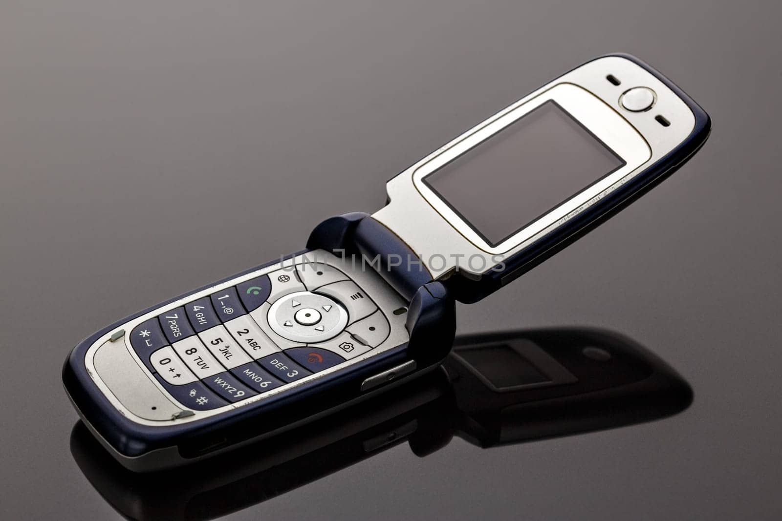 Old worn old-fashioned mobile phone on a gray background