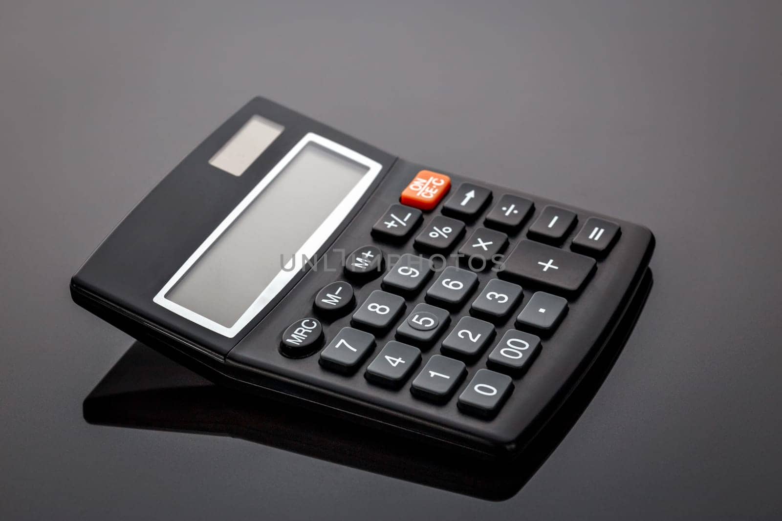 Old black old-style calculator on gray background