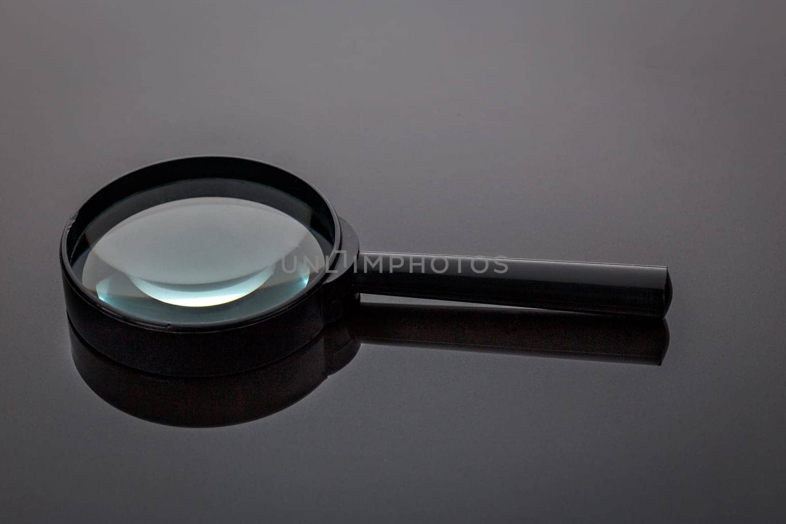 Old magnifying glass in black plastic frame