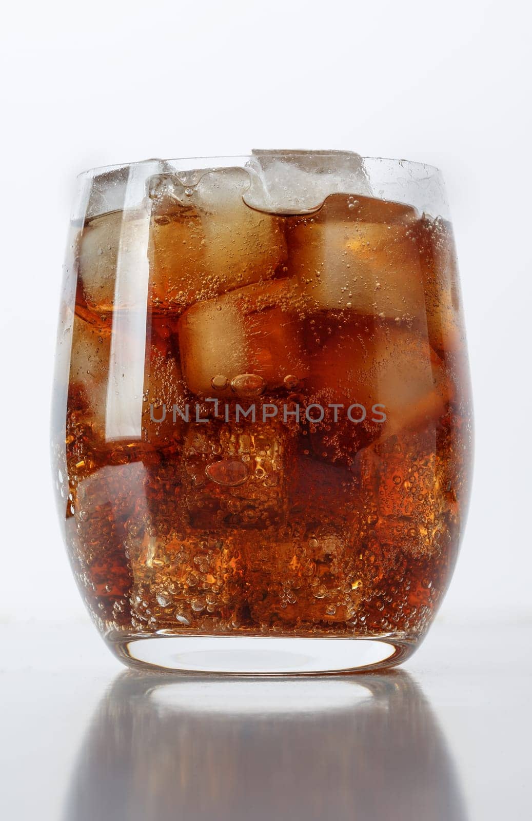Fizzy drink with ice on a white table