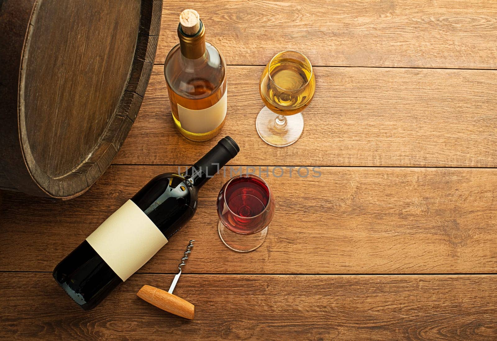 Glass and bottle of red wine and white wine with wooden barrel background