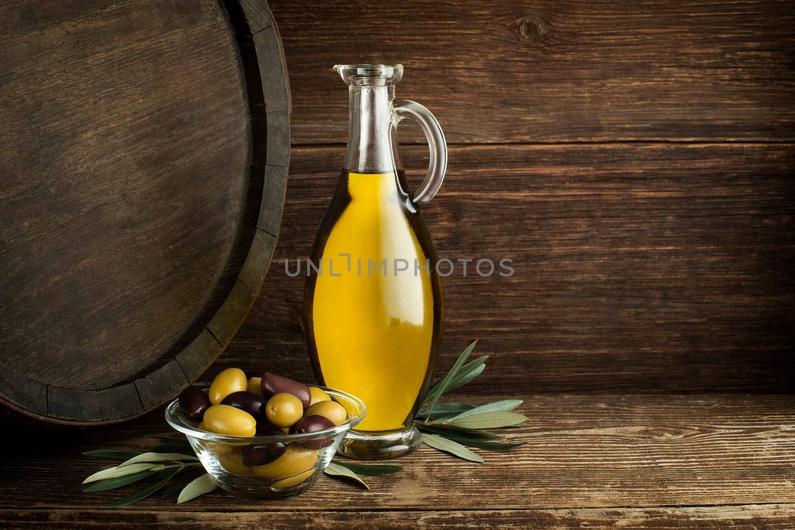Bottle of Extra virgin healthy Olive oil with barrel background