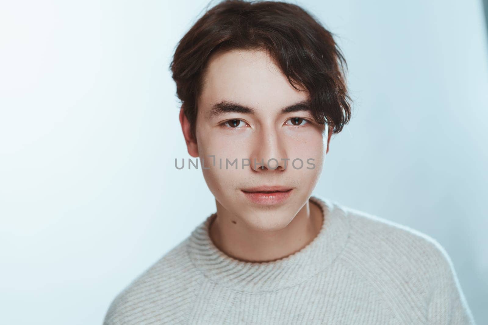 portrait of a teenager brunette guy in a studio.