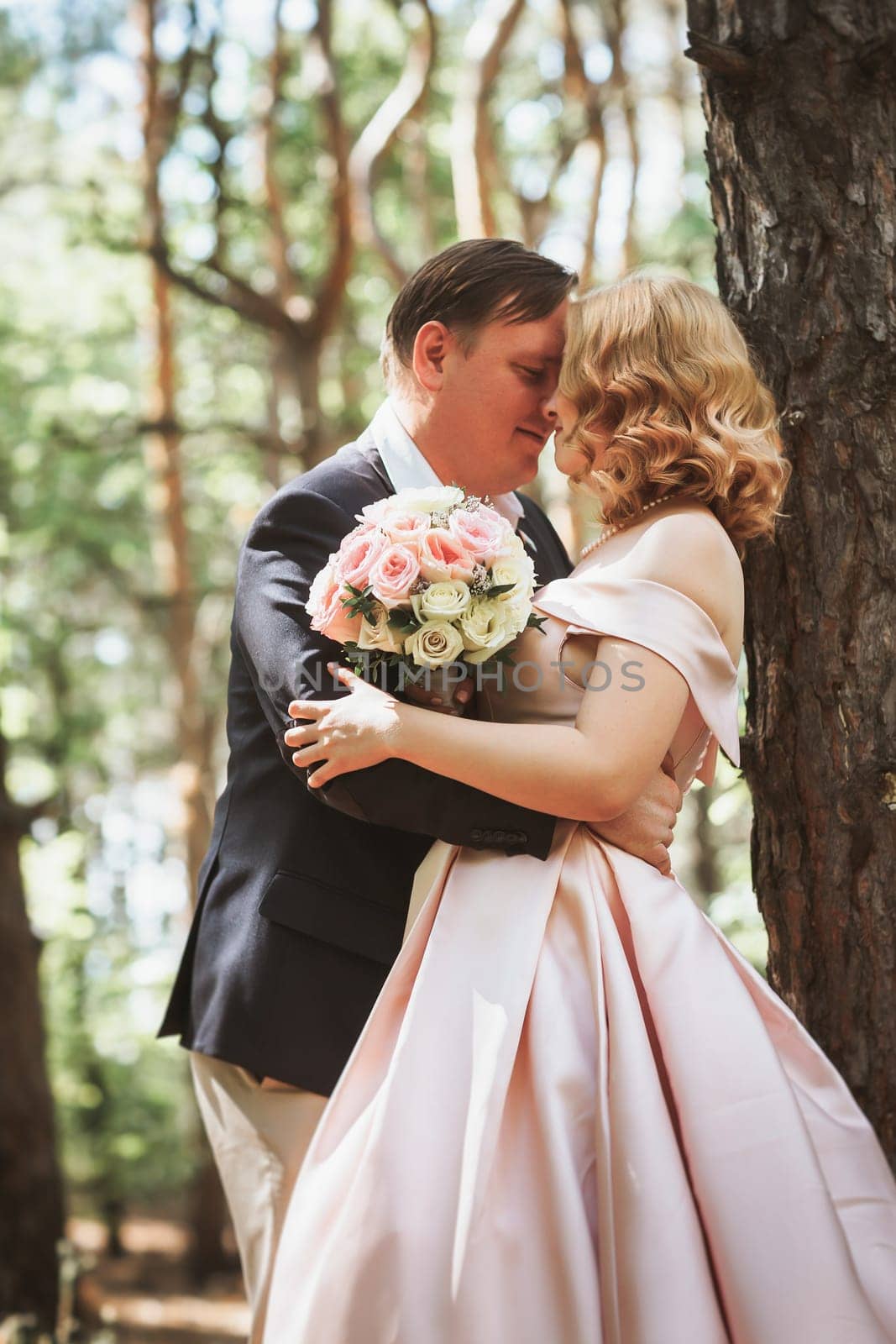 bride and groom kiss on the background of trees and forest.