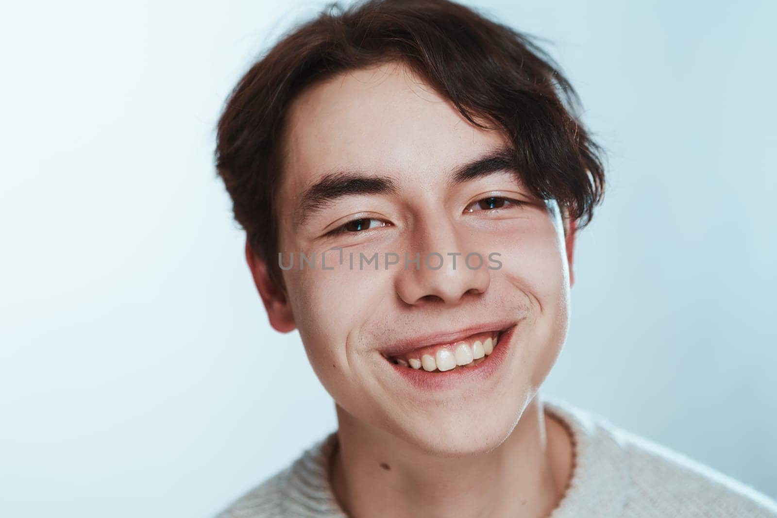 portrait of a teenager brunette guy in a studio.