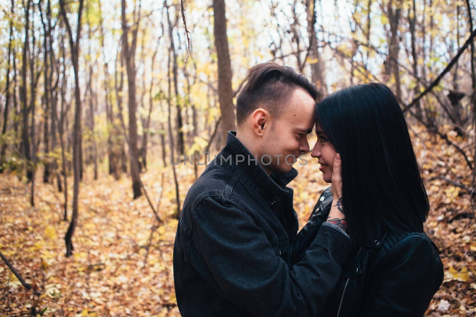 portrait of a young woman and a man walking in the autumn forest.