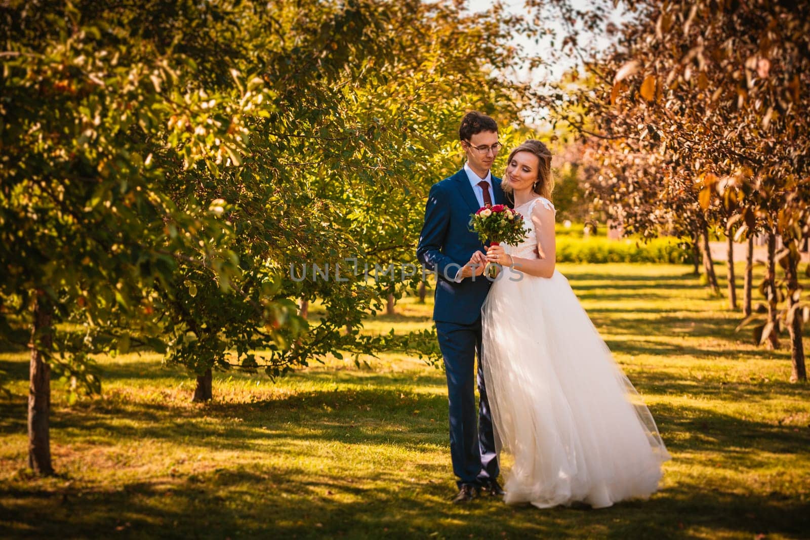 Beautiful stylish bride and groom on garden background.