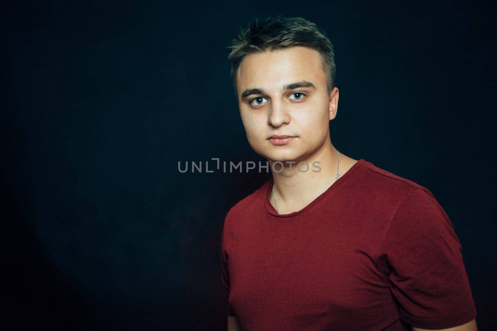 portrait of a young man on a dark background.