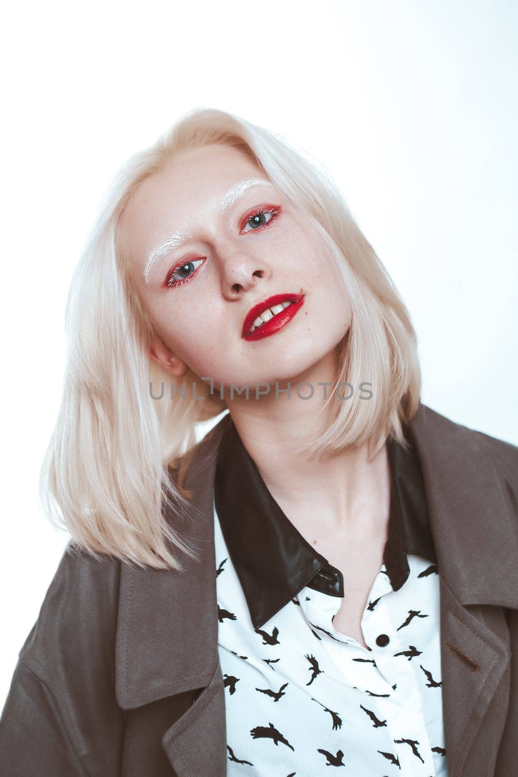 portrait of an albino girl in a raincoat in the studio.