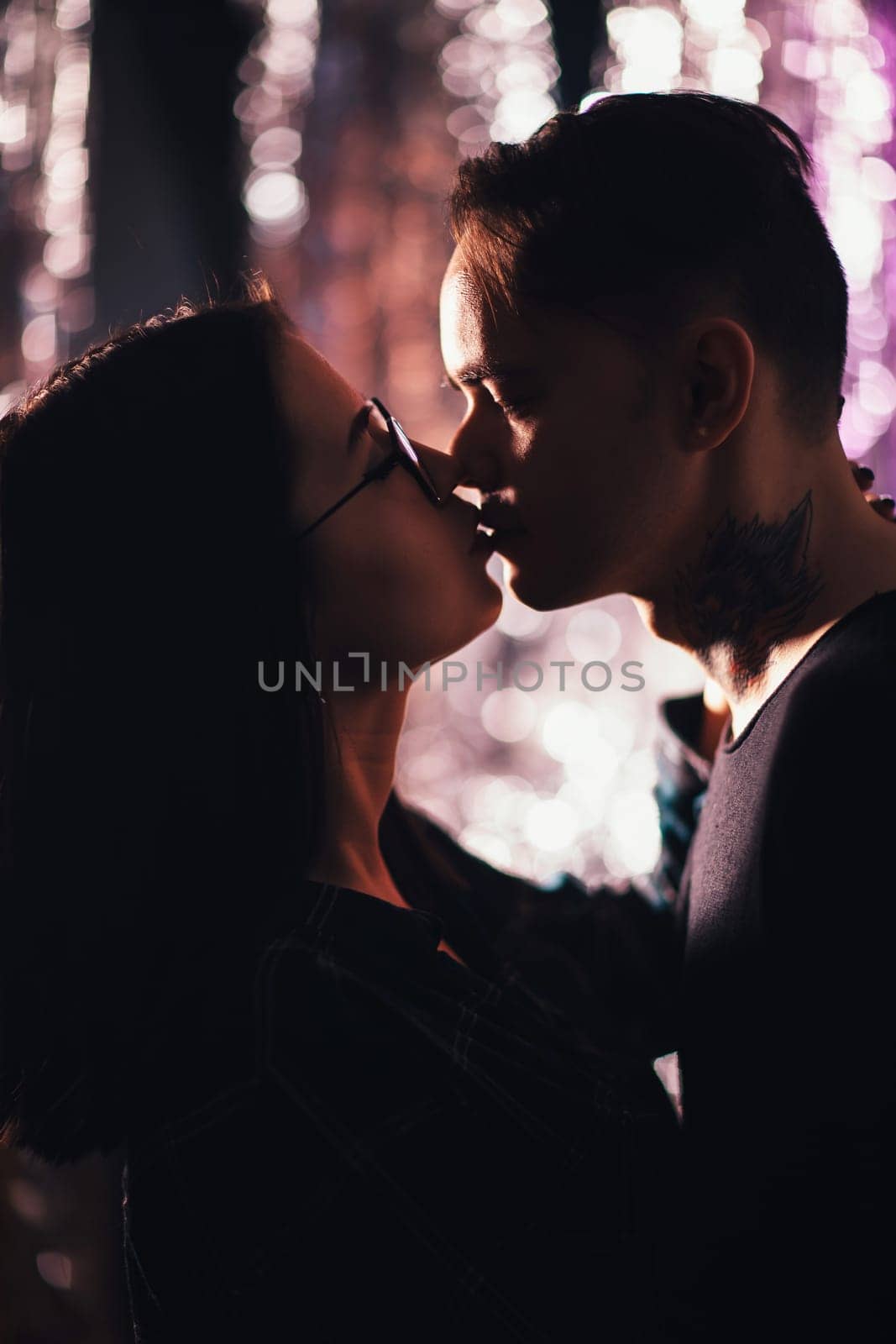 Couple in fashionable clothes on a shiny background.
