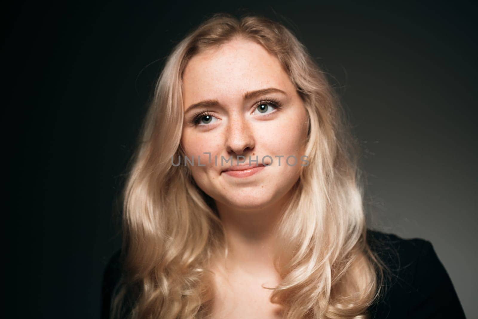 young girl blonde on a dark background.