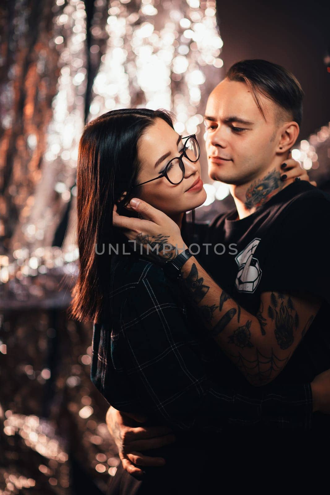 Couple in fashionable clothes on a shiny background.
