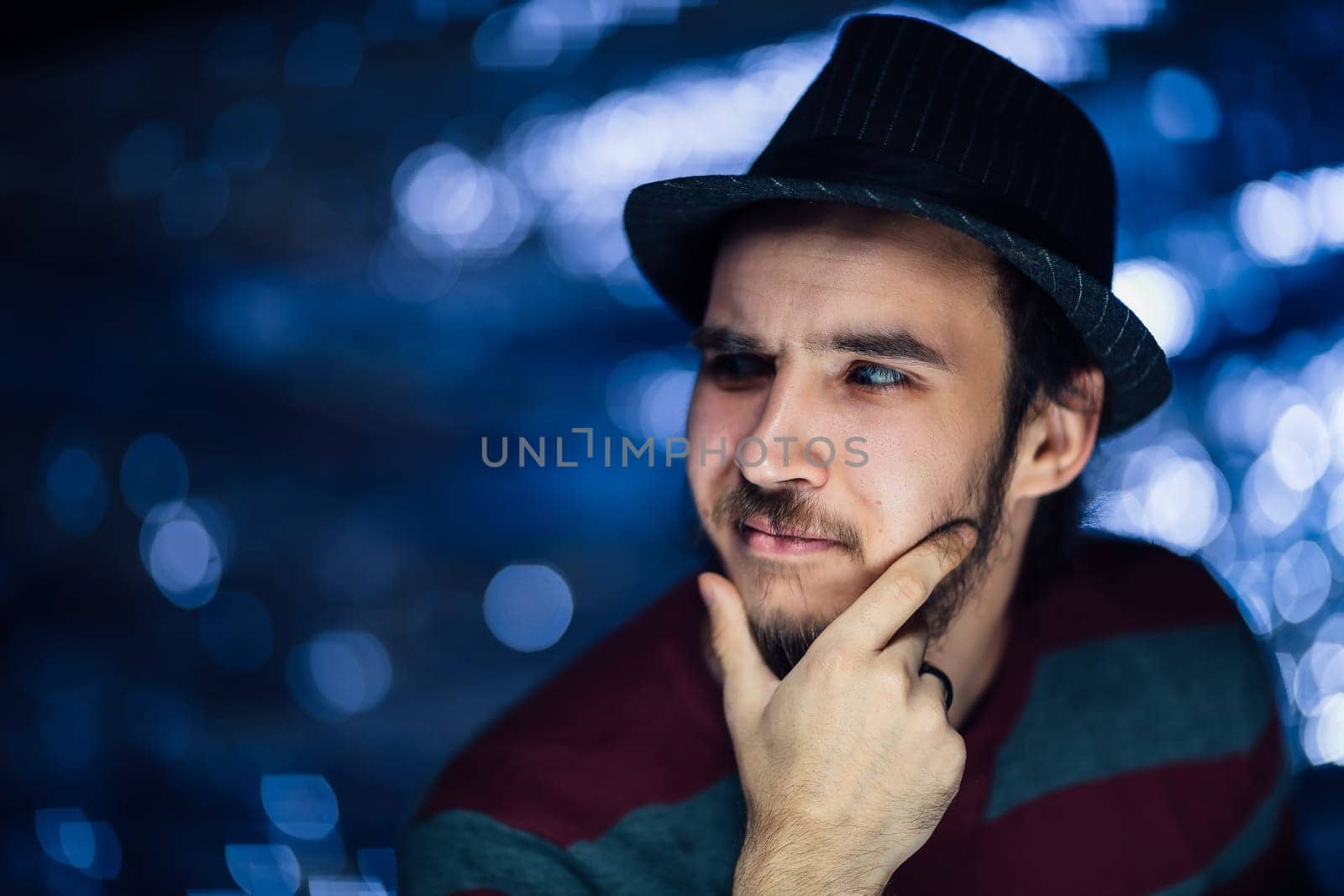 portrait of a guy in a hat on a blurred background.