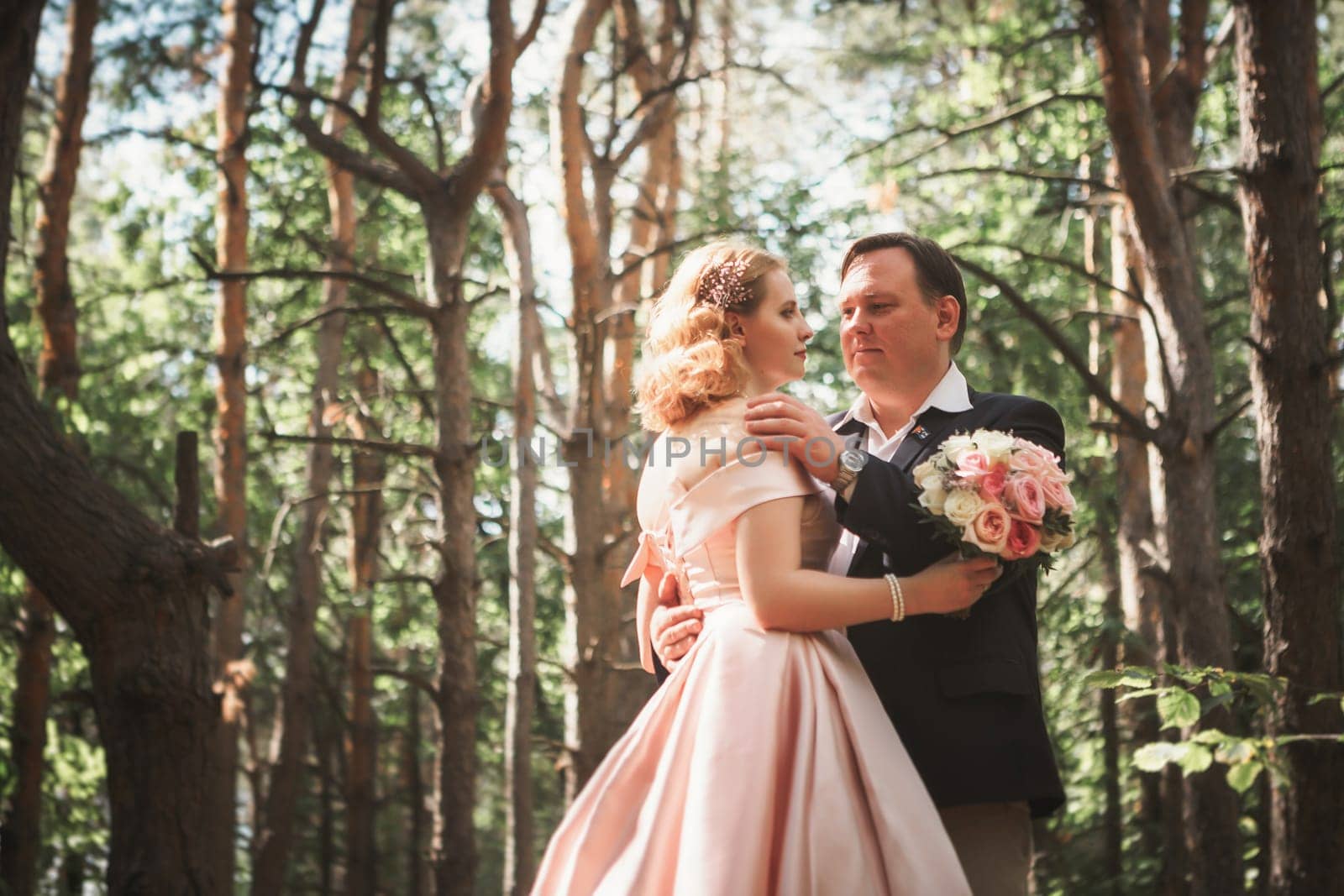 bride and groom on the background of trees and woods in full growth.