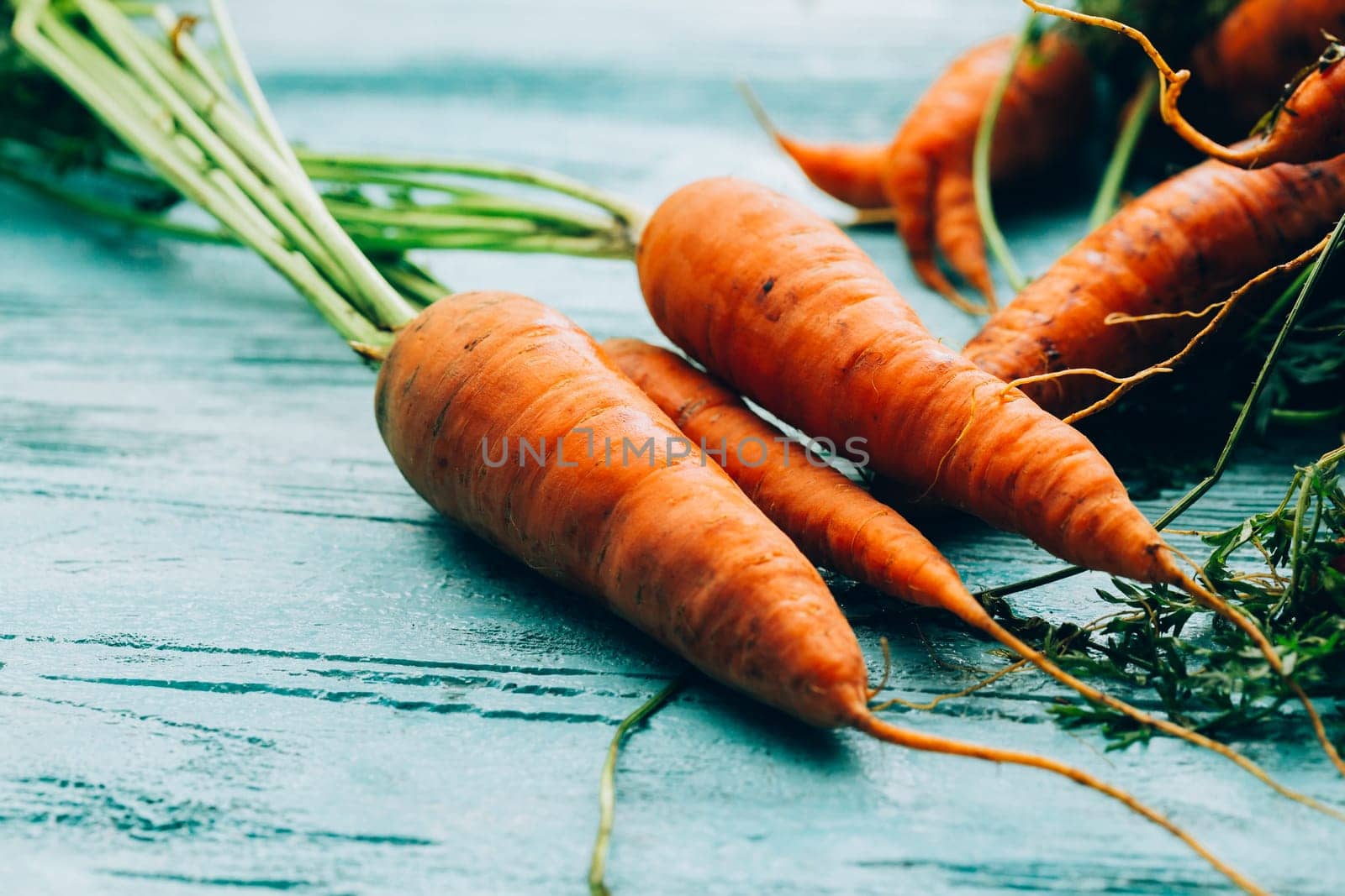 lot of carrots on a wooden background.