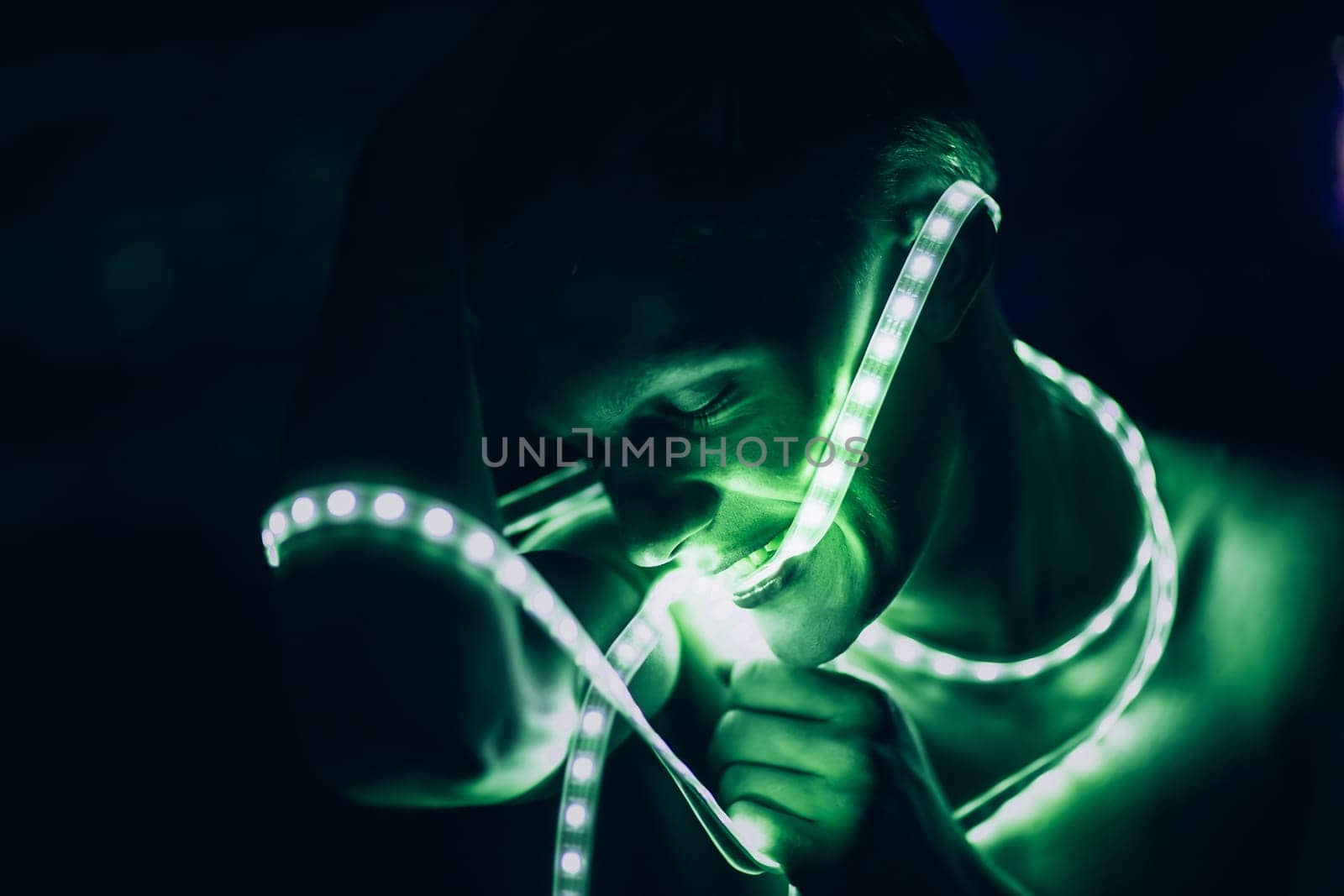 Portrait man Strip Light LED tape on dark color background.