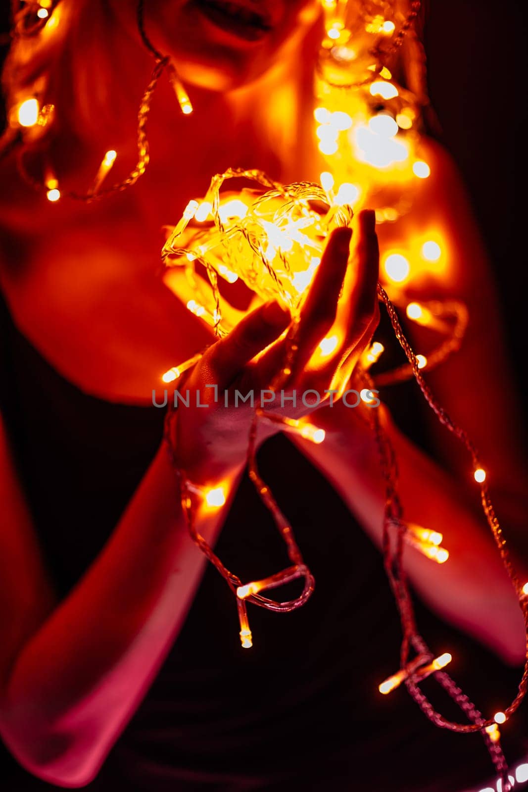 portrait of a girl with a garland on black background.
