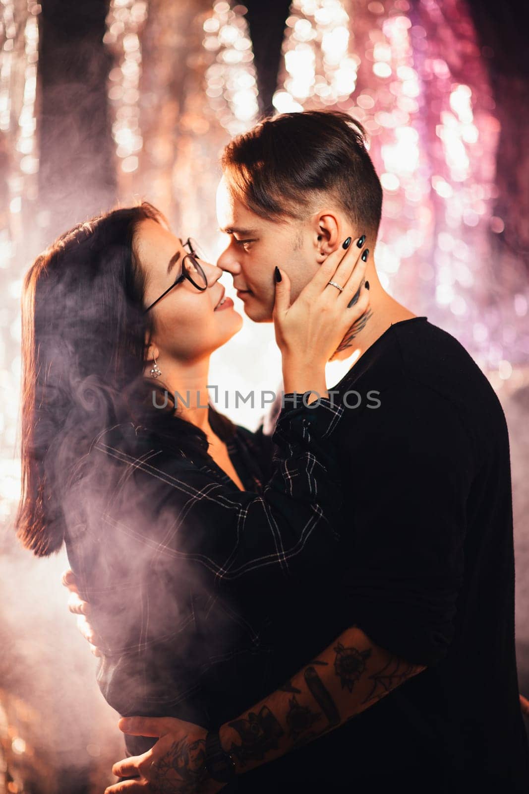 Couple in fashionable clothes on a shiny background.