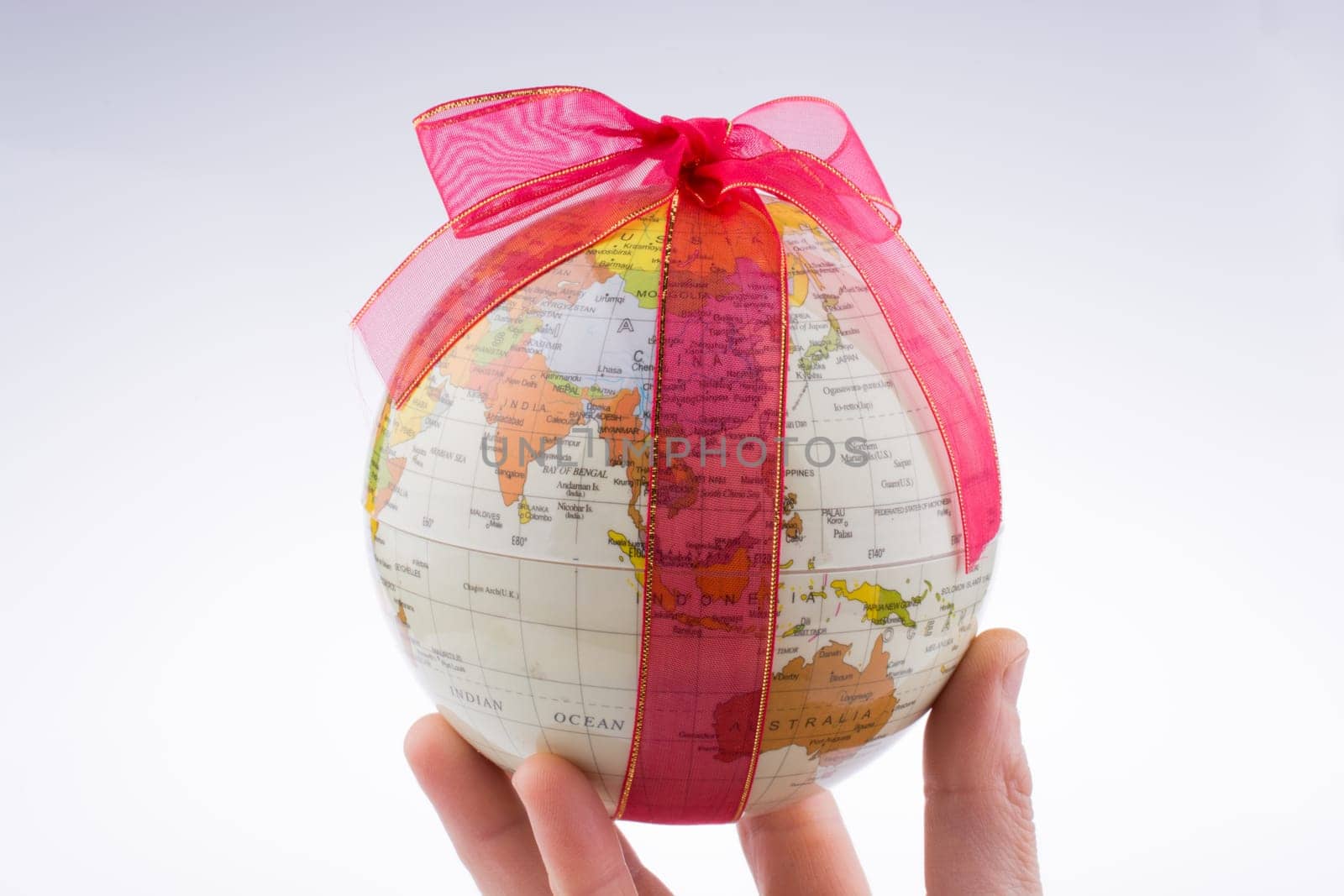Globe tied with red ribbon on a white background