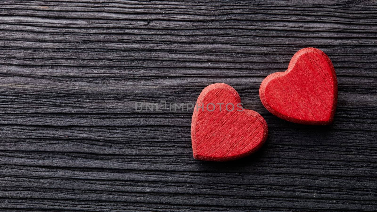Two decorative hearts on a dark wooden background with copy space. top view. Valentine's Day card. Design element for romantic greeting card, wedding invitation