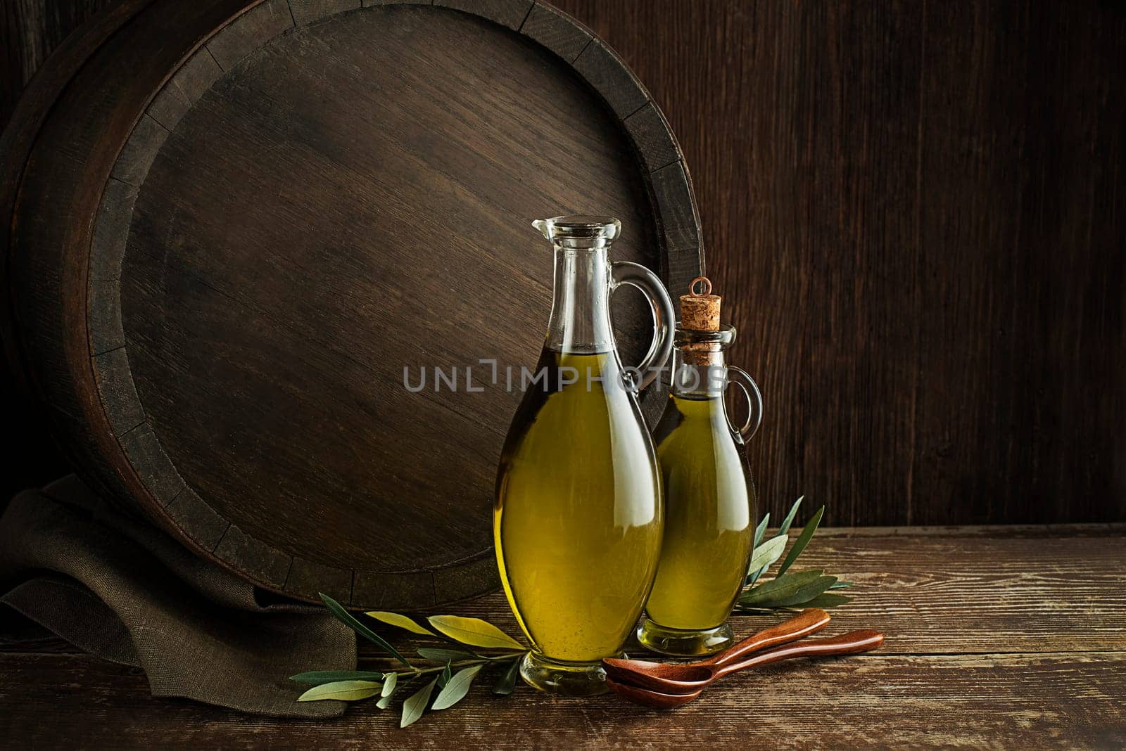 Bottles of Extra virgin healthy Olive oil with barrel background