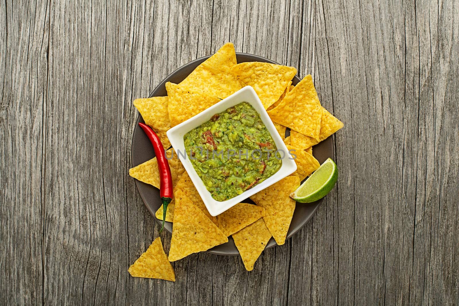 Guacamole sauce with corn nachos chips on plate
