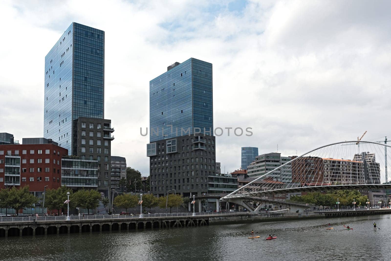 View on two towers Torres de Urbitrate and the pedestrian bridge over the Nervion river in Bilbao, Spain