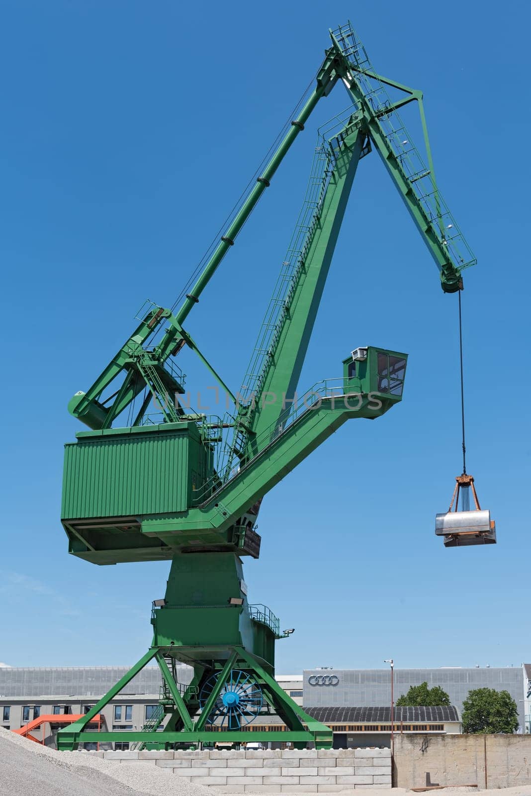 Exterior view of a cement factory with green crane