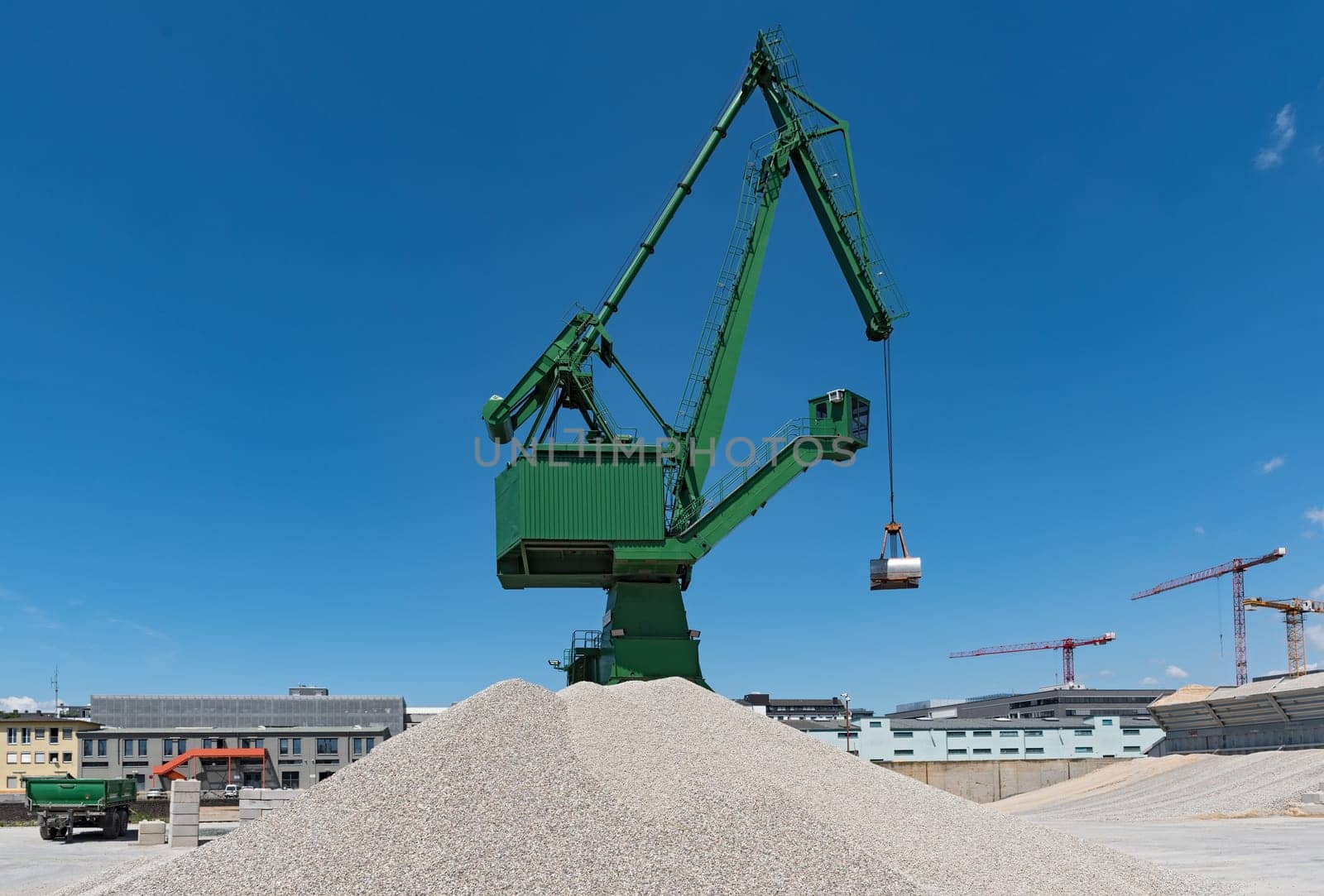 Exterior view of a cement factory with green crane