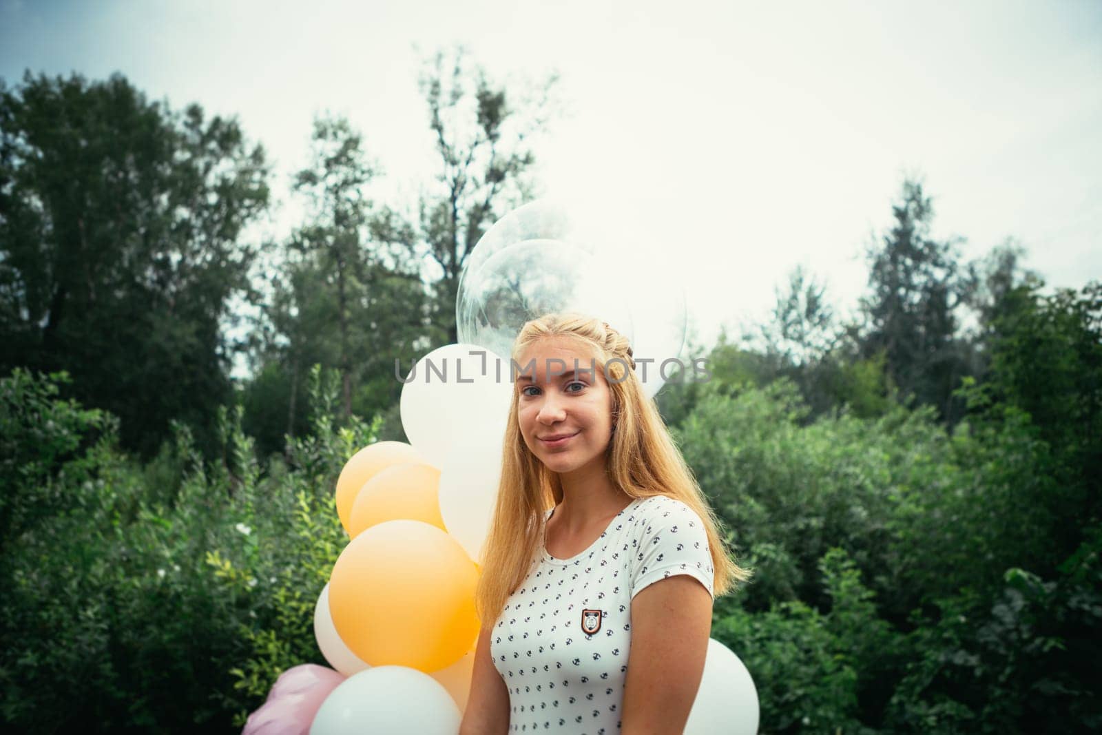 young girl with balloons on nature background.