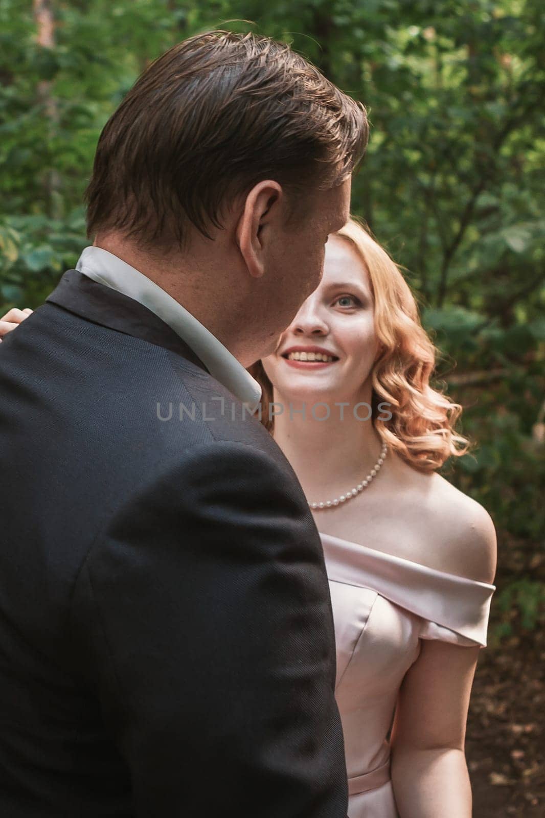bride and groom dancing in the forest background and sunlight.