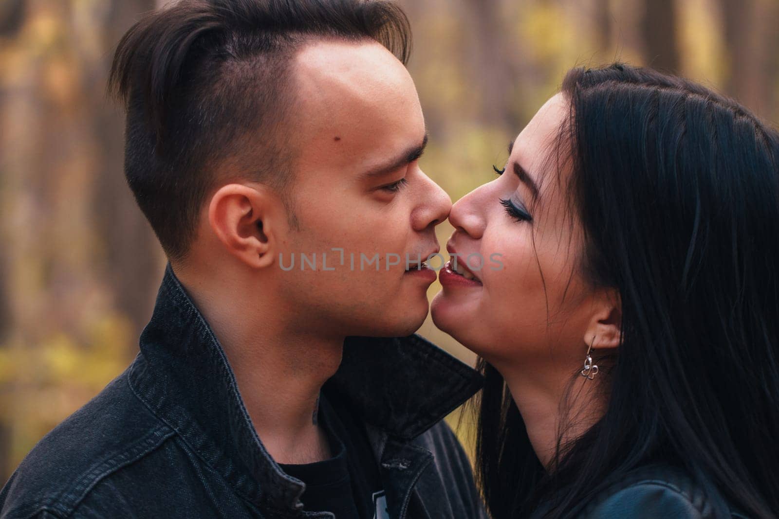 portrait of a young woman and a man walking in the autumn forest.