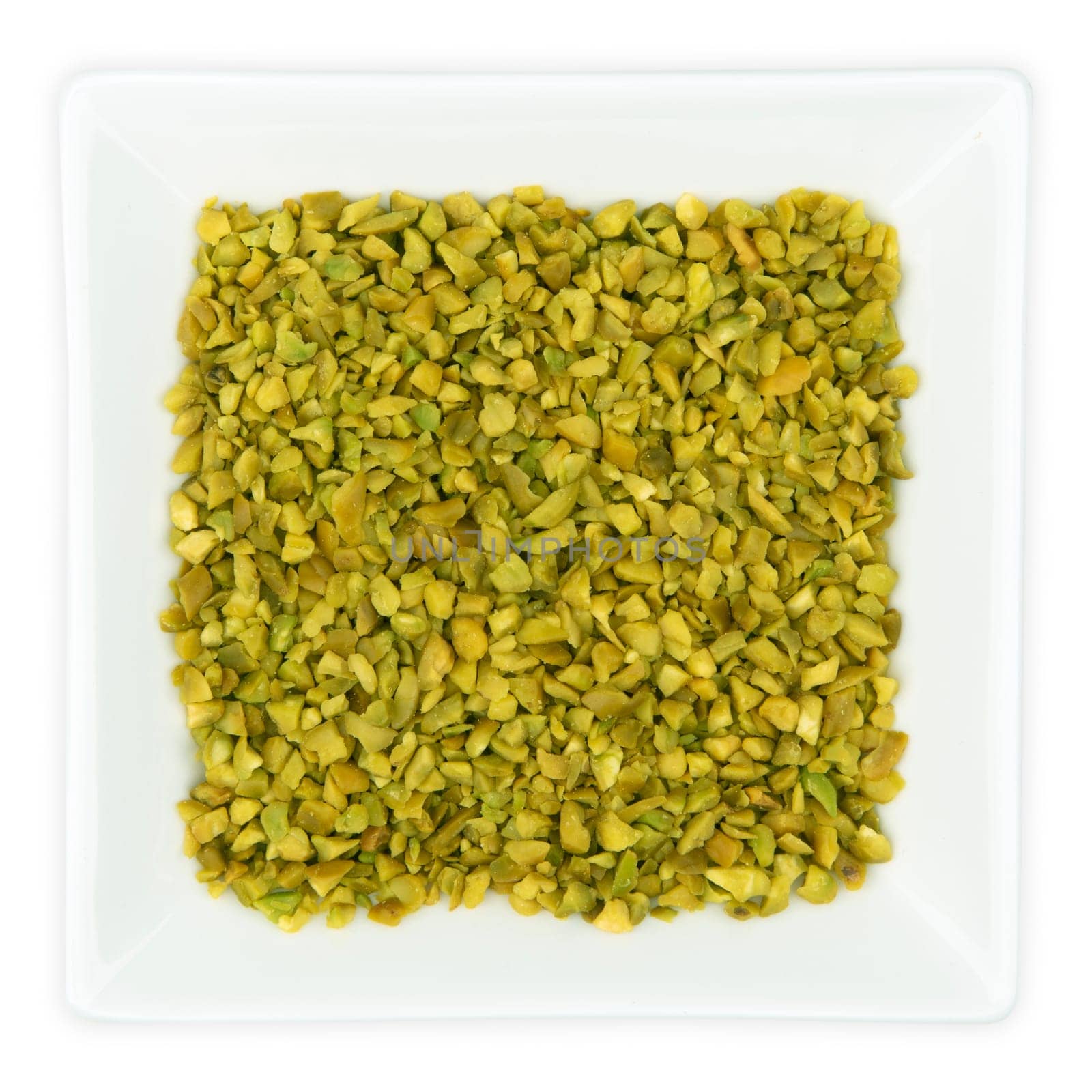Chopped Pistachios in a bowl isolated on white background