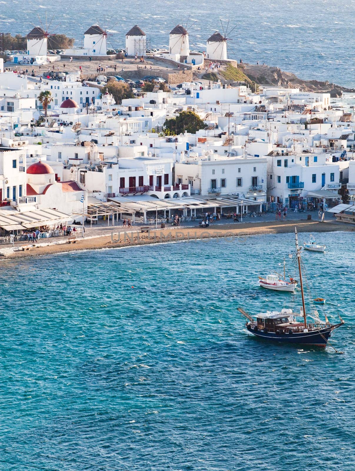panoramic view of the Mykonos town harbor with famous windmills from the above hills on a sunny summer day, Mykonos, Cyclades, Greece