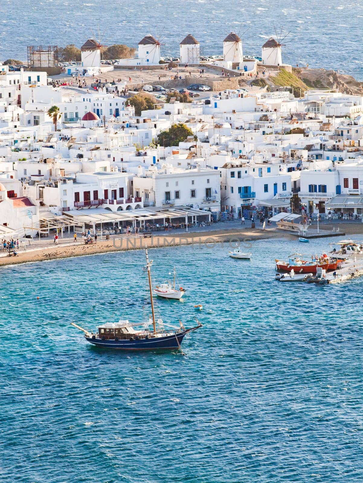panoramic view of the Mykonos town harbor with famous windmills from the above hills on a sunny summer day, Mykonos, Cyclades, Greece