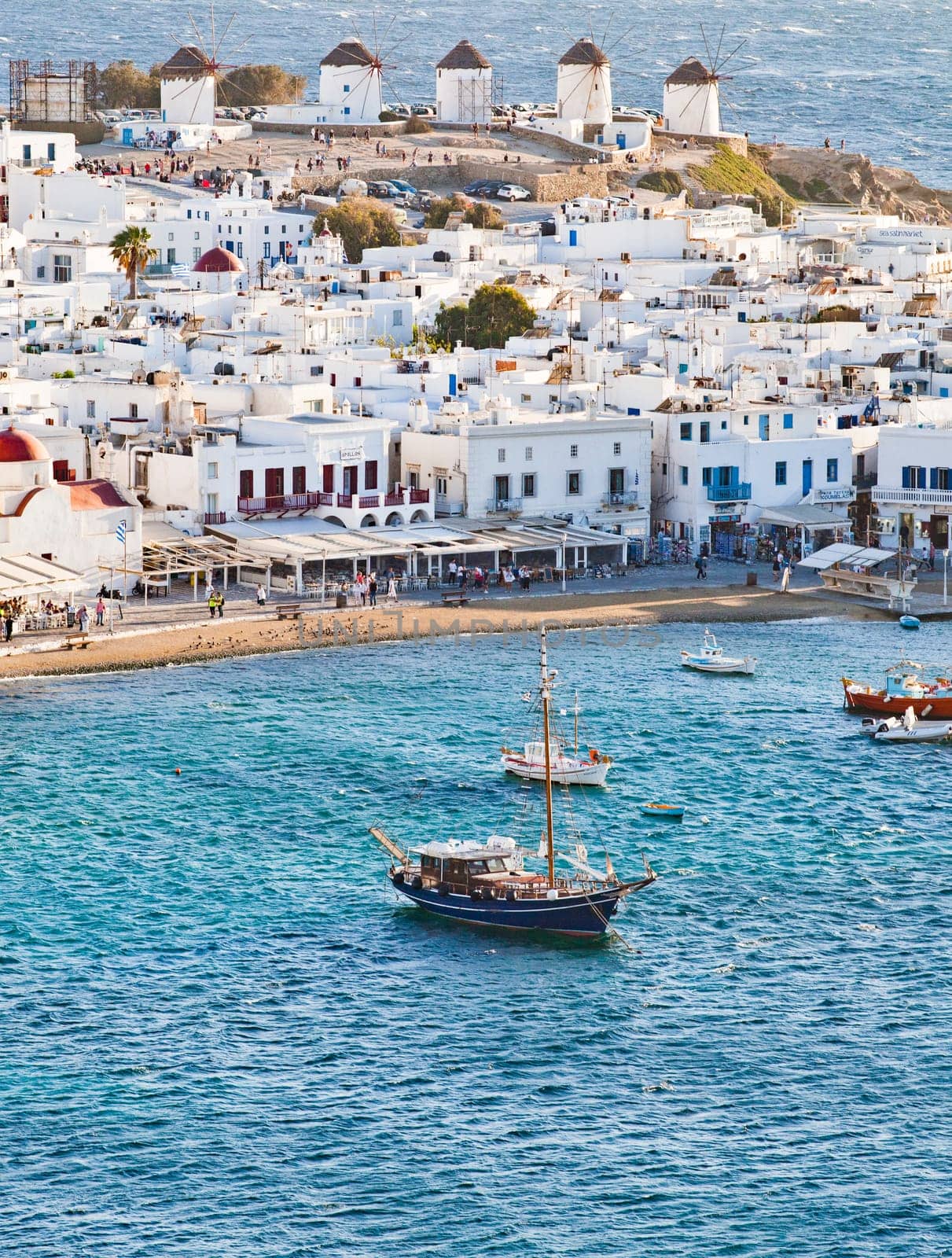 panoramic view of the Mykonos town harbor with famous windmills from the above hills on a sunny summer day, Mykonos, Cyclades, Greece