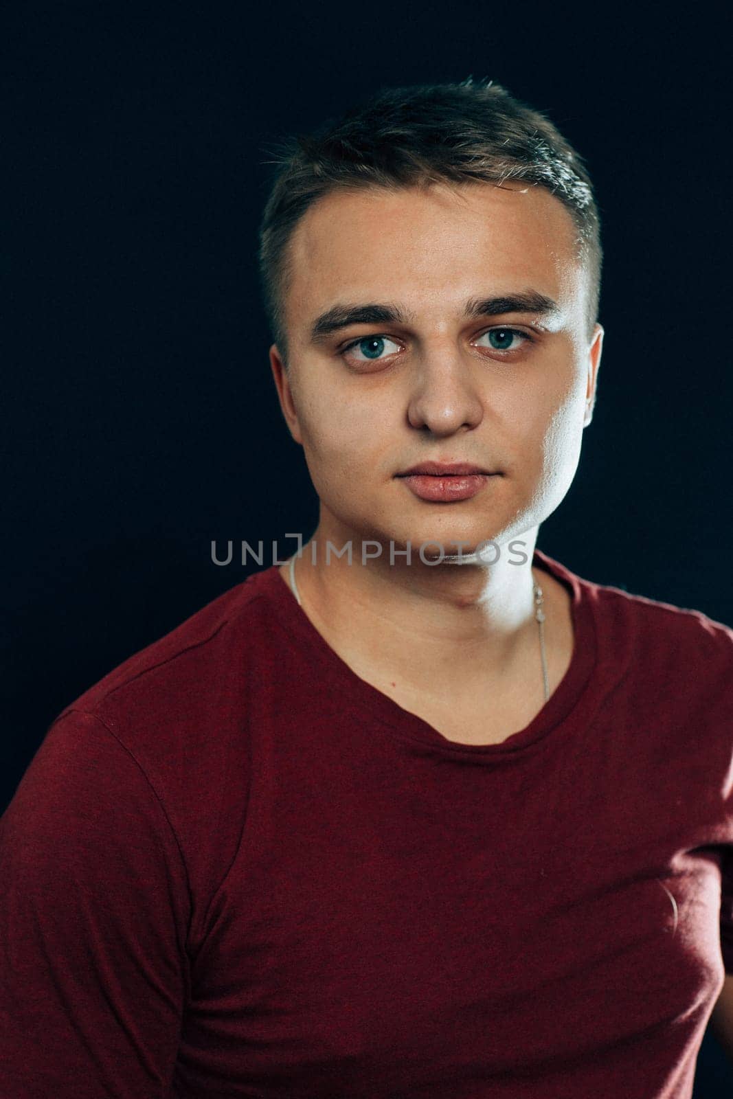 portrait of a young man on a dark background.